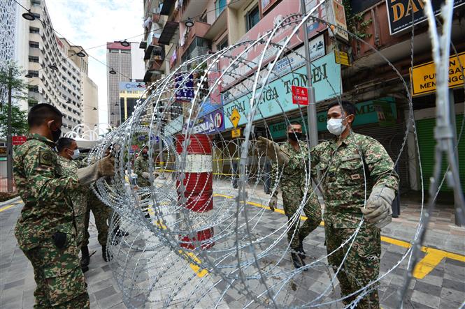 Binh sĩ Malaysia đặt rào chắn để thực hiện Mệnh lệnh Kiểm soát Di chuyển (MCO) tại Kuala Lumpur, Malaysia. Ảnh: THX/TTXVN