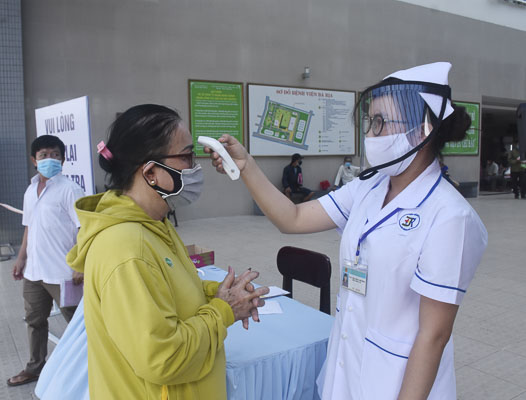 Nhân viên Bệnh viện Bà Rịa đo thân nhiệt người đến khám, chữa bệnh.