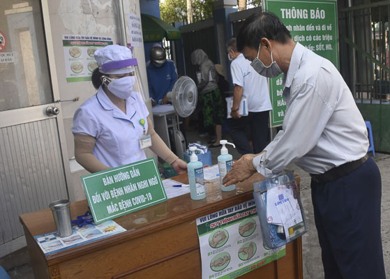 Người dân khai báo y tế, rửa tay sát khuẩn, được kiểm tra thân nhiệt trước khi vào khám bệnh tại Bệnh viện  Lê Lợi. Đây là một trong những biện pháp giám sát, sàng lọc người có biểu hiện nghi ngờ COVID-19, nhằm phòng tránh lây nhiễm chéo dịch bệnh trong bệnh viện.