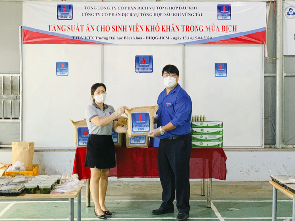 Đại diện Đoàn Trường ĐH Bách khoa TP.Hồ Chí Minh (bên phải) nhận các suất ăn từ PSV. Ảnh: HUỲNH GIA