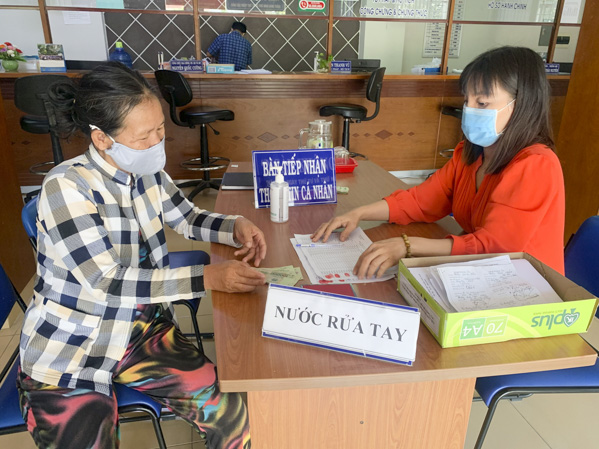 Cán bộ xã An Ngãi (huyện Long Điền) trao tiền hỗ trợ cho người bán vé số lẻ trên địa bàn xã. Ảnh: NGỌC TUYỀN
