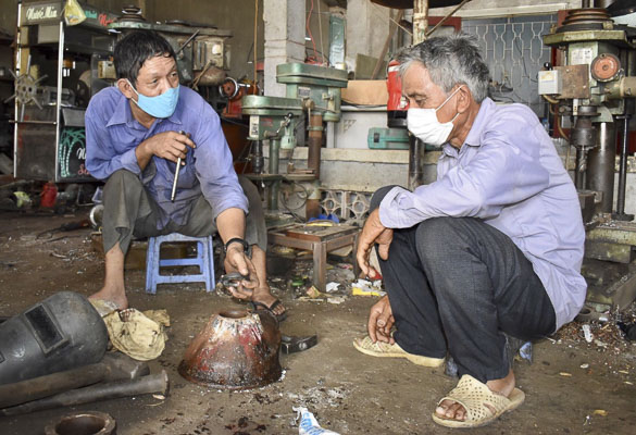 Anh Nguyễn Công Tiến sửa máy xay bột cho khách hàng.