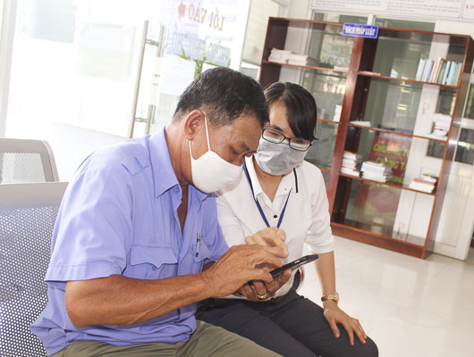 Ông Lê Hữu Đức (ở đường Cô Giang) đến làm giấy khai sinh cho cháu nội và được chị Huyền Trang hướng dẫn đánh giá bằng hình thức quét mã QR code trên ứng dụng Zalo.
