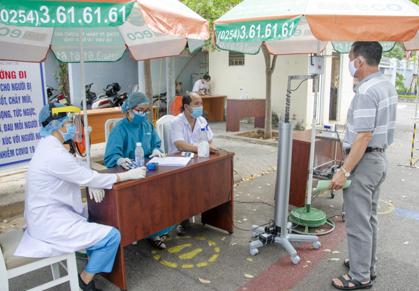 Nhân viên Trung tâm Y tế Vietsovpetro điều khiển từ xa thiết bị đo thân nhiệt đối với người đến khám bệnh, liên hệ công việc.