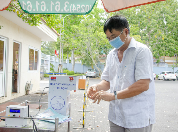 Người dân đến khám bệnh, liên hệ công việc tại Trung tâm Y tế Vietsovpetro  sát khuẩn tay bằng thiết bị rửa tay tự động. 