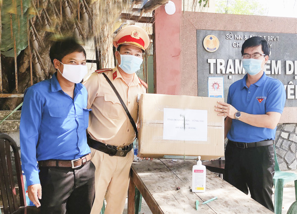 Anh Nguyễn Văn Tuân, Phó Bí thư Tỉnh Đoàn (phải) trao tặng khẩu trang cho Chốt kiểm tra  y tế tại xã Bình Châu, huyện Xuyên Mộc. Ảnh: MINH THANH