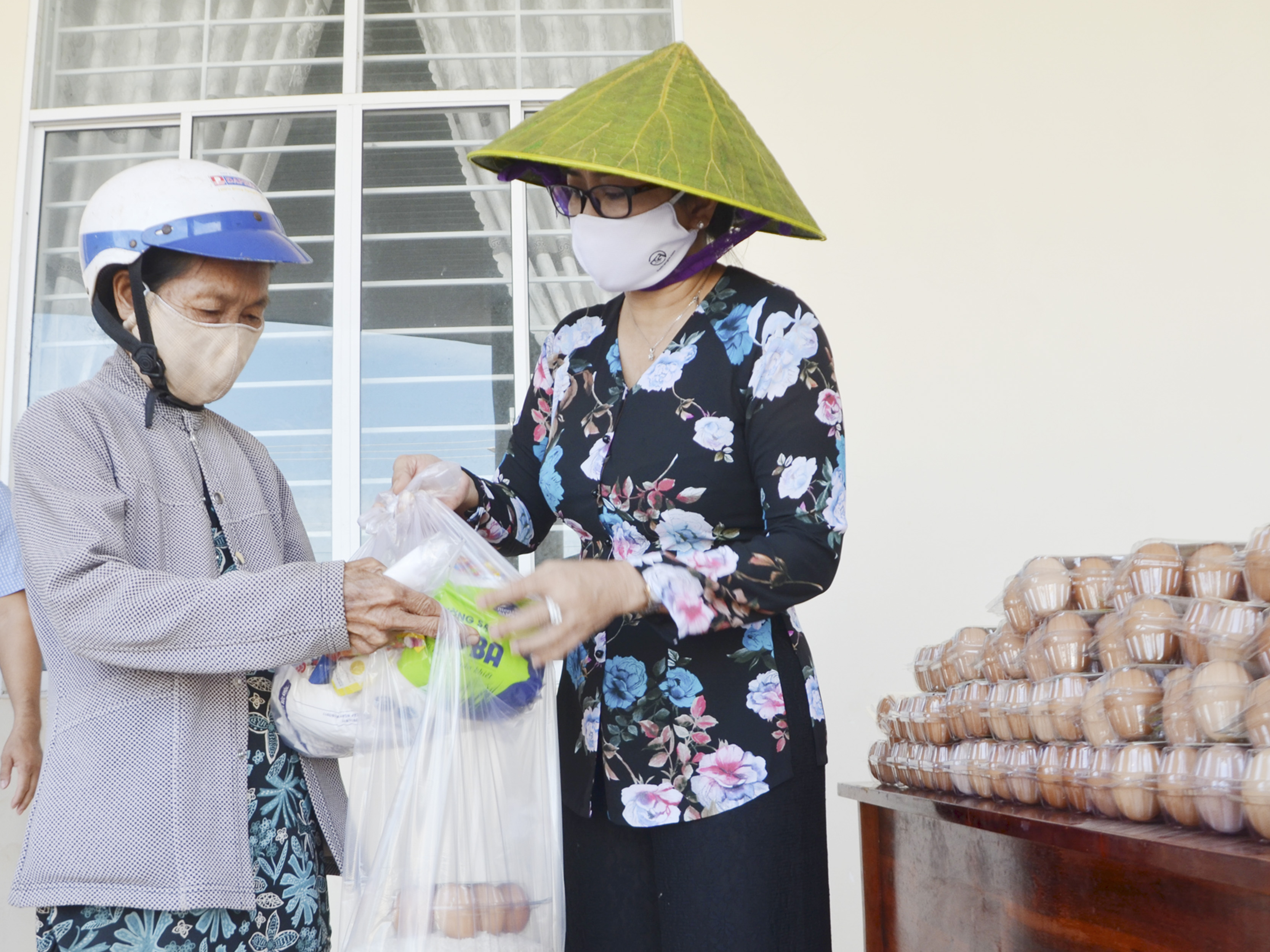 Bà Lê Thị Trang Đài (bìa phải), Chủ tịch UBND huyện Xuyên Mộc tặng quà cho người dân đến nhận gạo tại cây ATM gạo. Ảnh: DIỄM QUỲNH