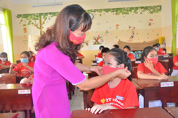 Cô Nguyễn Thị Xuân, giáo viên chủ nhiệm lớp 5A1, Trường TH Quang Trung (TP.Vũng Tàu) tặng khẩu trang cho HS trong buổi đến trường đầu tiên sau kỳ nghỉ dài phòng, chống dịch.