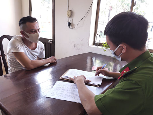 Nguyễn Minh Tiếp (trái) khai nhận vụ việc tại cơ quan công an.