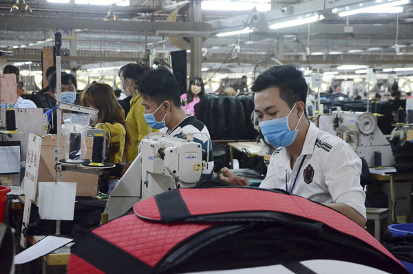 Do ảnh hưởng của dịch COVID-19, các DN hoạt động trong ngành dệt, may mặc, giày da, túi xách, ba lô...  gặp nhiều khó khăn do thiếu nguồn nguyên liệu sản xuất. Trong ảnh: Công nhân Công ty TNHH Tiwnle Việt Nam gia công va li xuất khẩu.