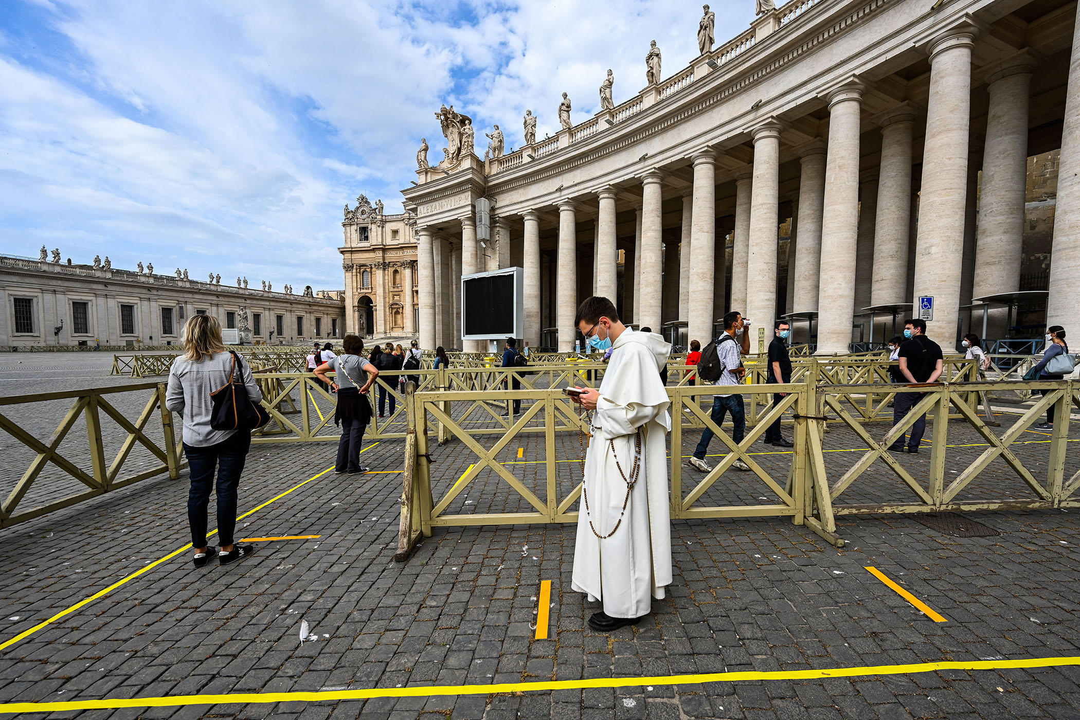 Du khách xếp hàng chờ kiểm tra thân nhiệt trước khi vào Nhà thờ Thánh Peter tại Tòa thánh Vatican ngày 18/5/2020. Ảnh: AFP