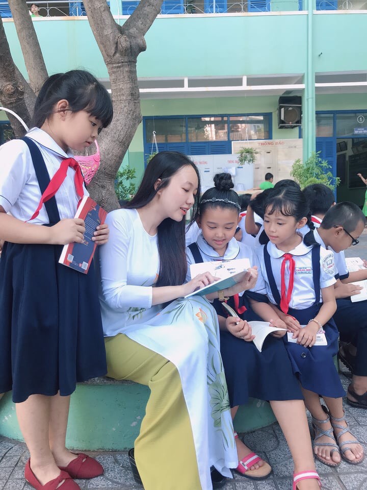 Cô giáo Nguyễn Thị Lan Thanh và HS lớp 4E, Trường TH Thắng Nhì trong giờ đọc sách dưới sân trường.