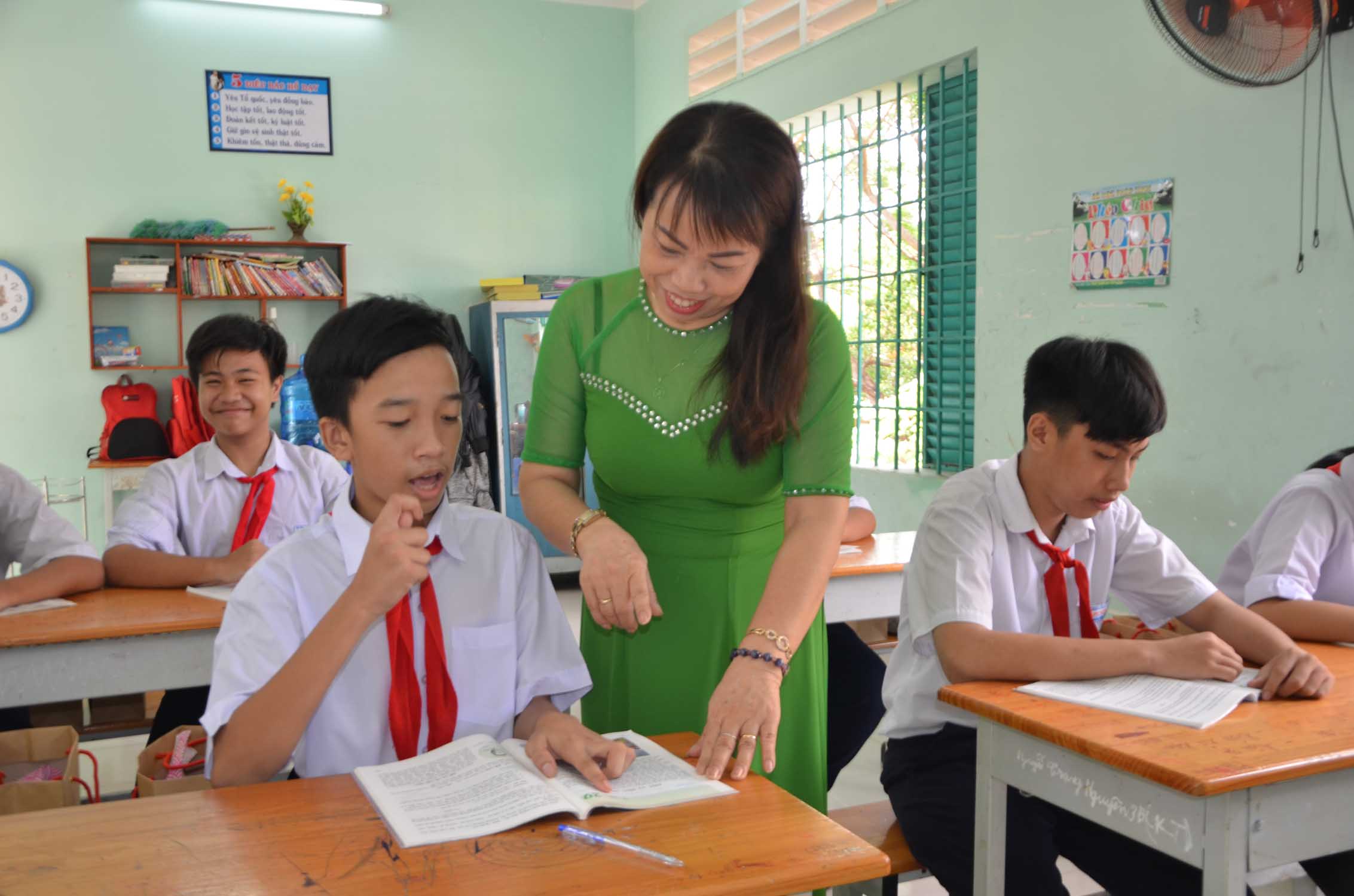 Cô Vũ Thị Luyên hướng dẫn em Nguyễn Tuấn Vũ, HS lớp 5 đọc bài trong giờ học Tiếng Việt.