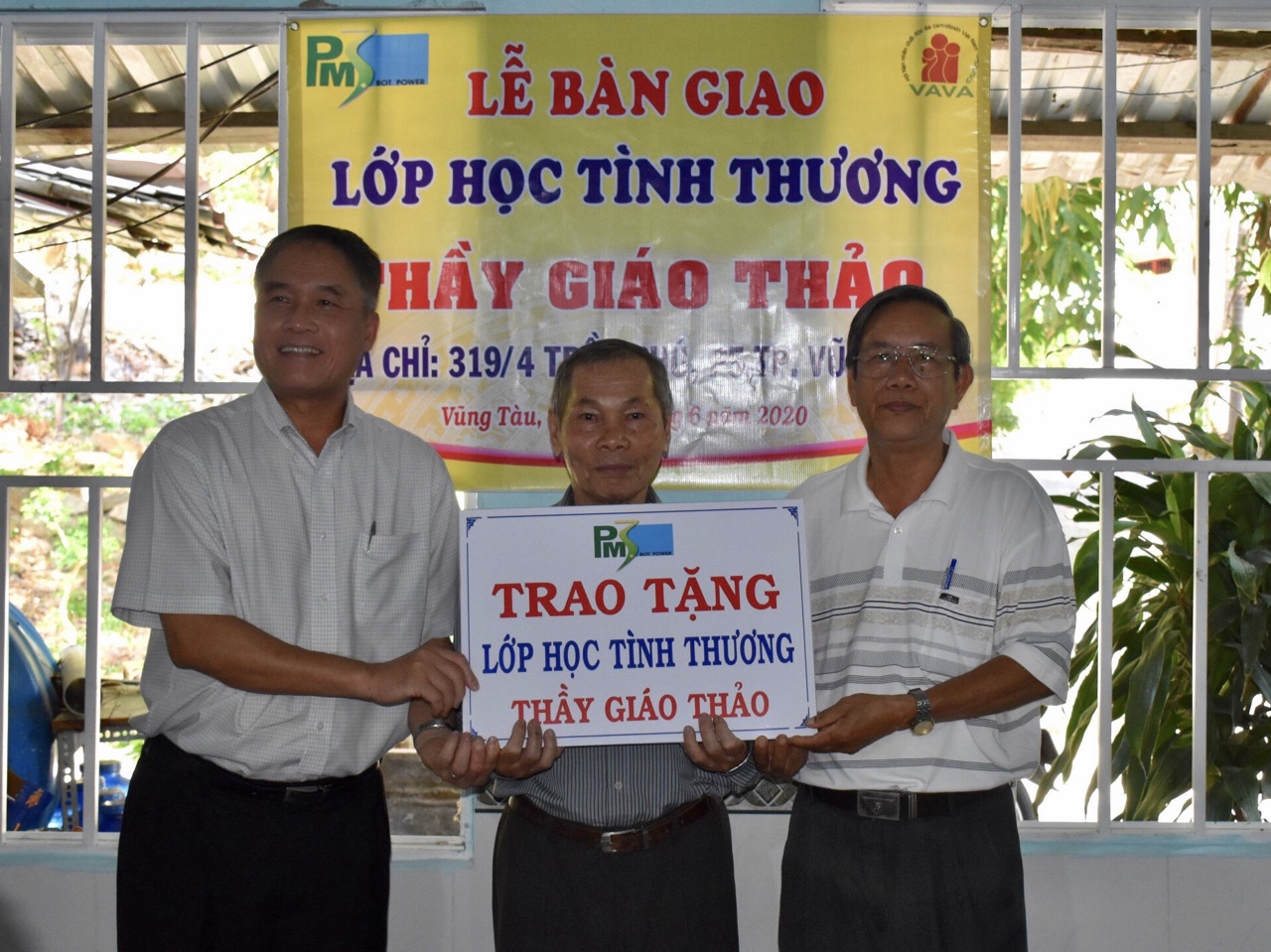 Ông Đỗ Bá Cảnh (bìa trái), Tổng Giám đốc Công ty Điện lực TNHH BOT Phú Mỹ 3 trao biểu trưng tặng lớp học tình thương cho ông Trần Đức Thảo. 