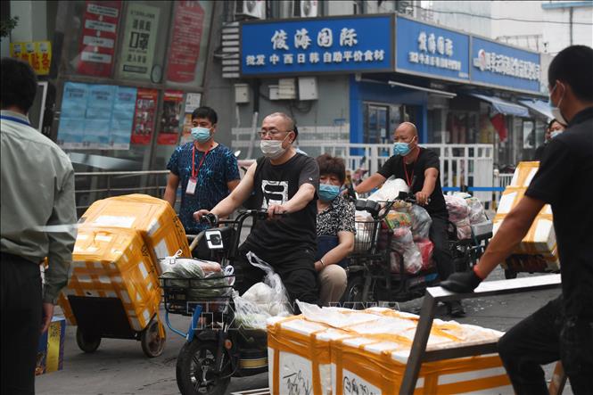 Người dân chuyển hàng hóa khỏi chợ Tân Phát Địa ngày 13/6 sau khi chợ phải đóng cửa để khử trùng do phát hiện các ca nhiễm COVID-19 mới. (Ảnh: AFP)