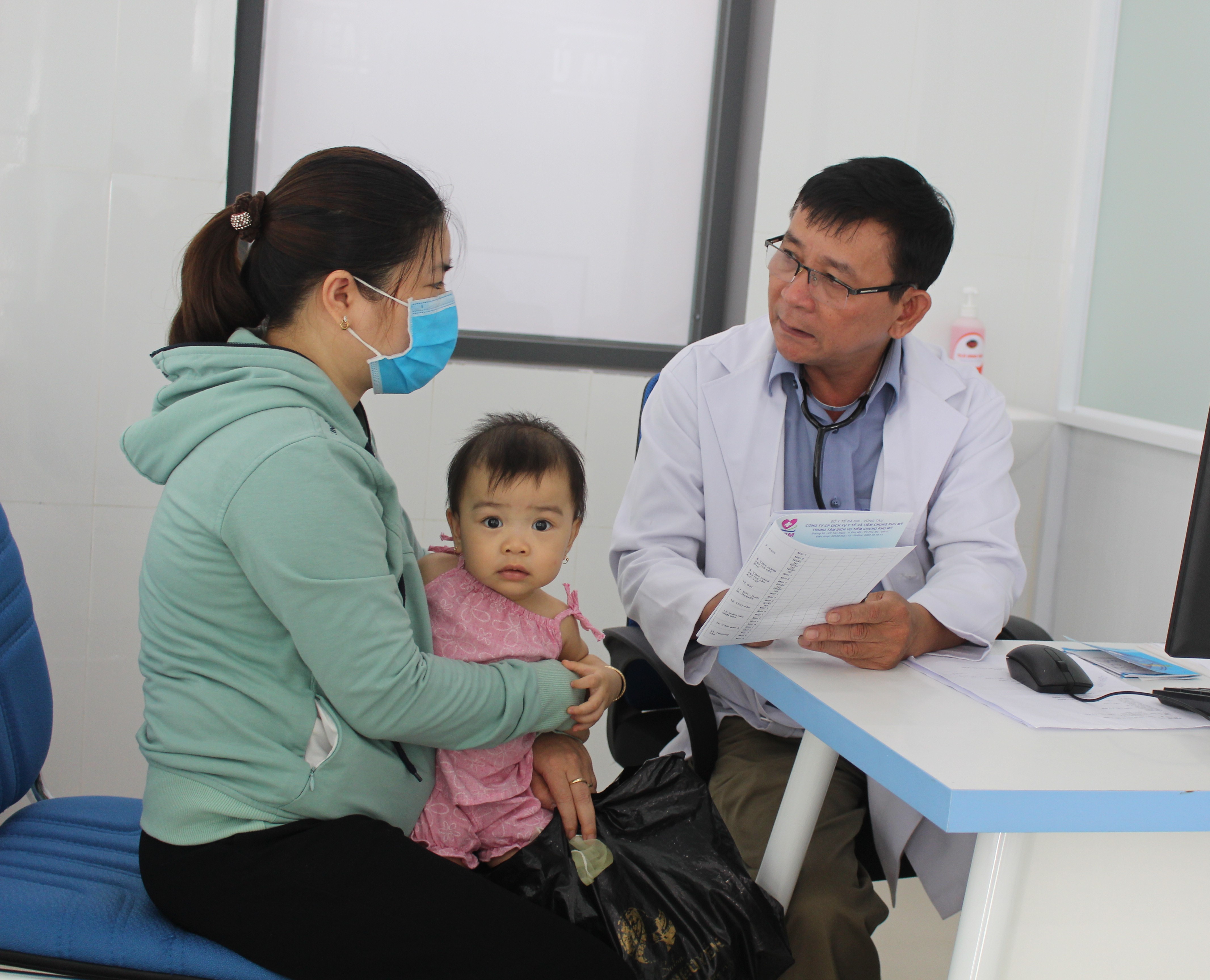 Trẻ em được bác sĩ tư vấn, khám sàng lọc sức khỏe trước khi tiêm chủng vắc xin tại trung tâm.