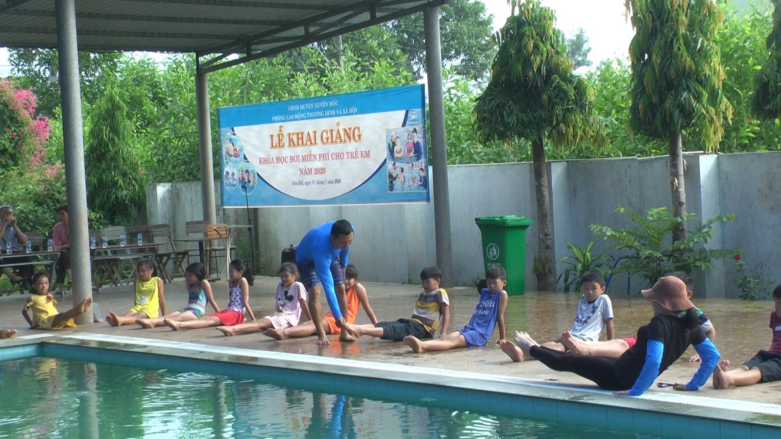 Các huấn luyện viên bơi hướng dẫn các em khởi động trước khi vào tập bơi.