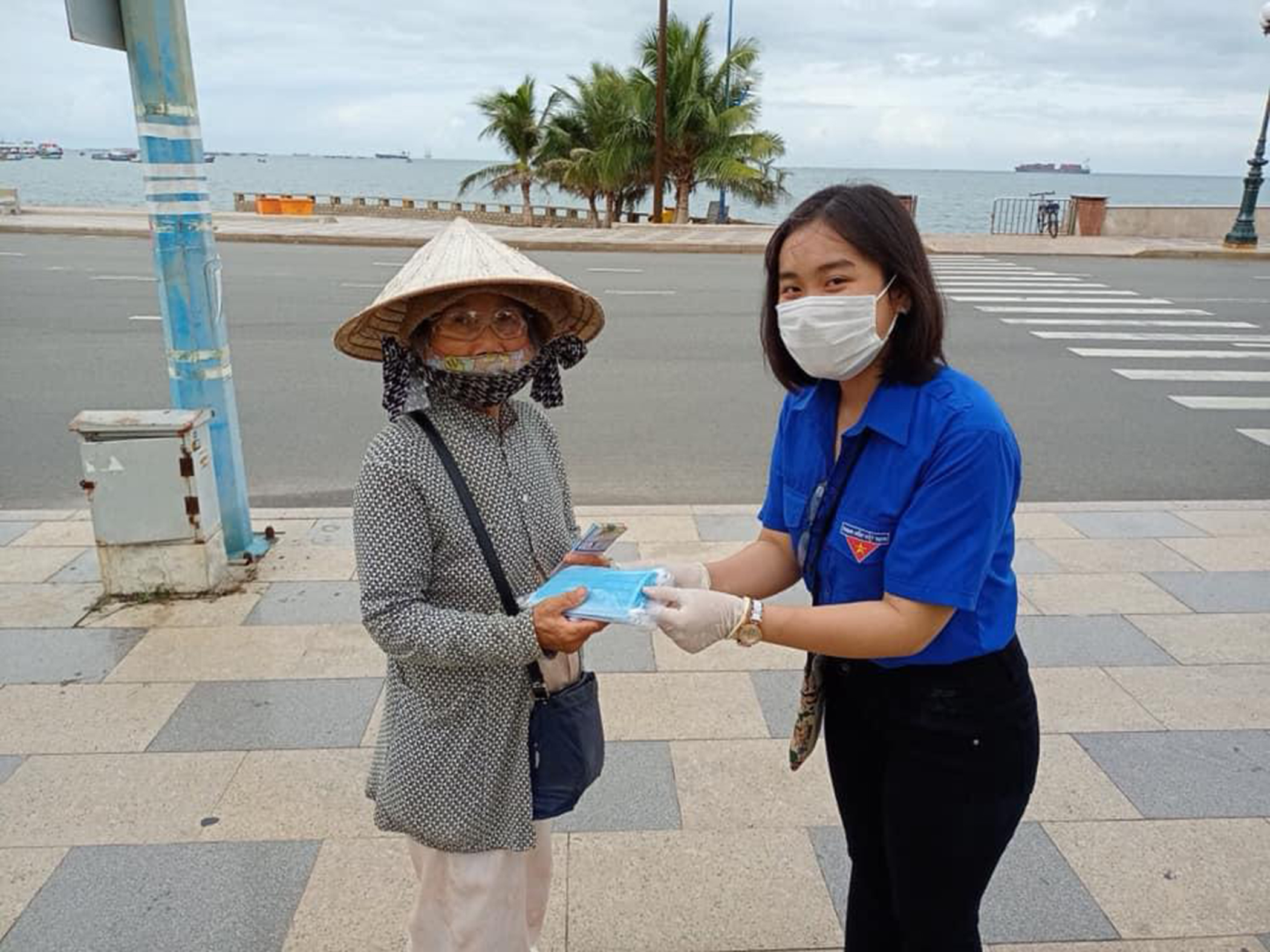 Đội tình nguyện Hoa phượng đỏ tặng khẩu trang y tế cho người bán vé số và tuyên truyền phòng chống COVID-19.