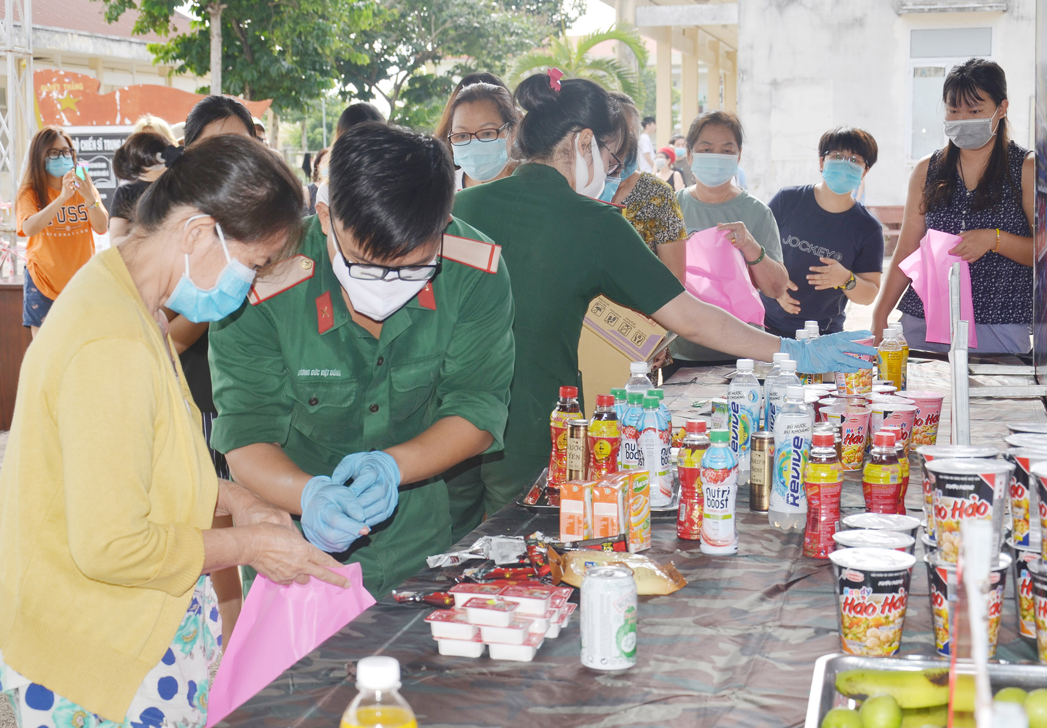 Cán bộ, chiến sĩ phát nhu yếu phẩm cho công dân đang cách ly tại Trung đoàn Minh Đạm.