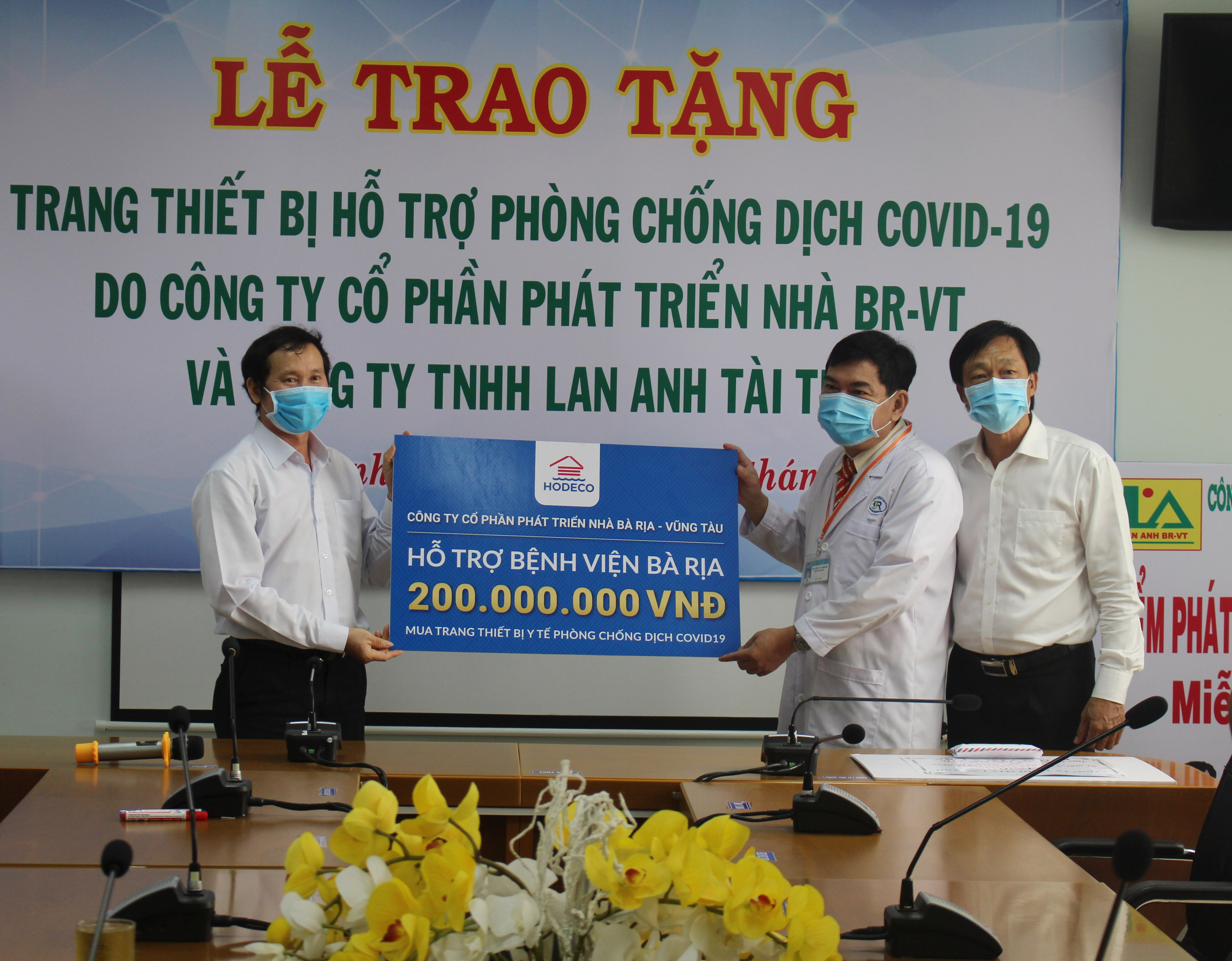 Ông Phan Văn Dinh, Chủ tịch Công đoàn Công ty CP Phát triển nhà BR-VT (bên phải) trao 200 triệu đồng cho đại diện Bệnh viện Bà Rịa.