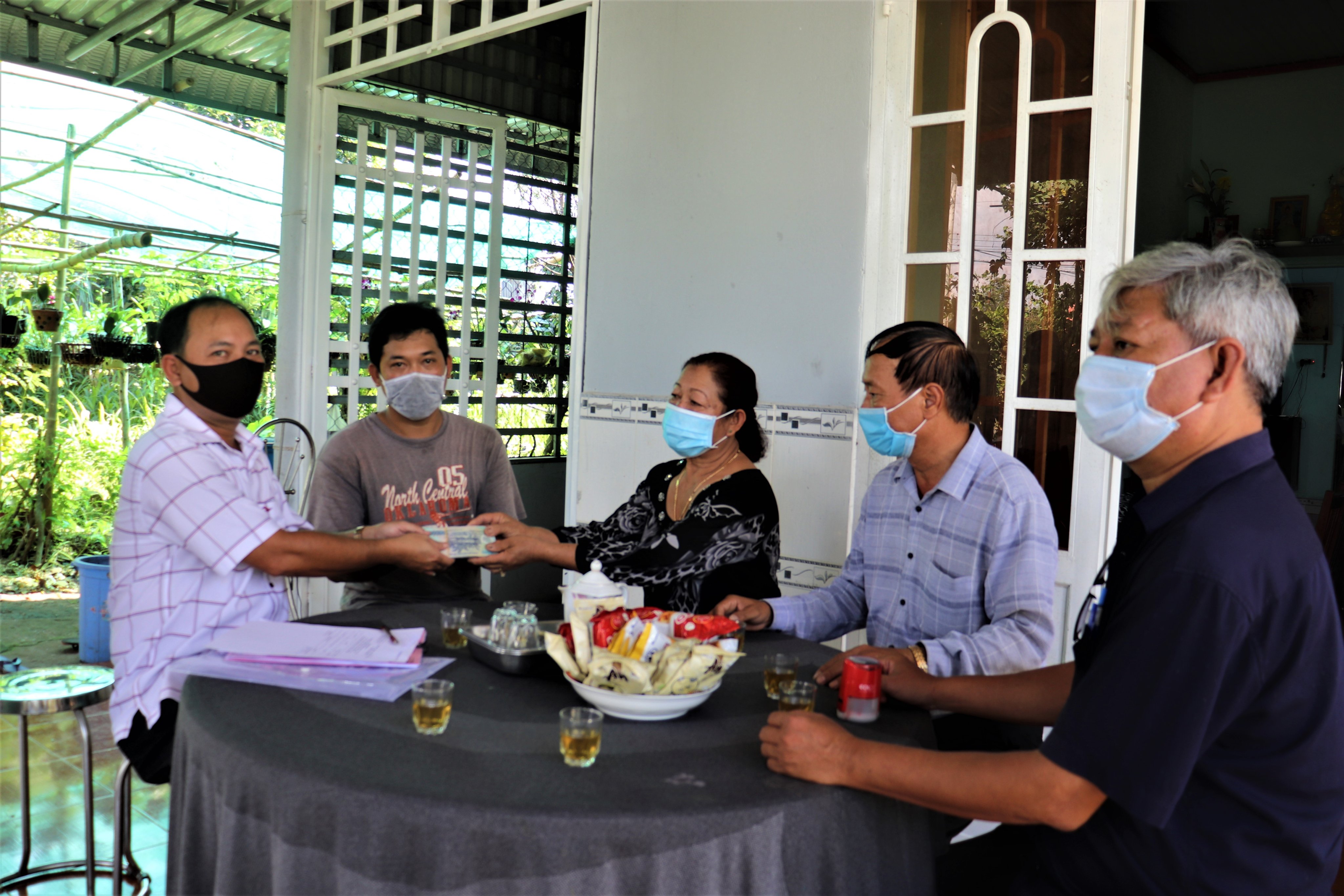  Ông Bùi Đình Nam (bìa trái), Phó Giám đốc Quỹ hỗ trợ nông dân tỉnh trao vốn vay cho gia đình hội viên Phạm Thị Diêm (thôn 3, xã Suối Rao) để mở rộng quy mô dự án nuôi heo rừng lai sinh sản.