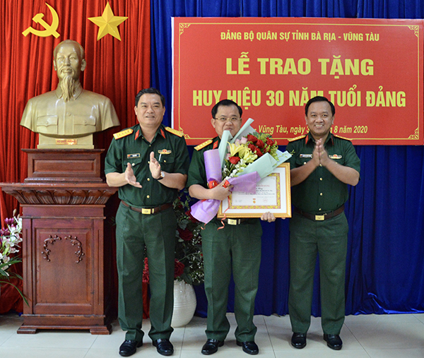 Đại tá Phạm Phú Ý, Chỉ huy Trưởng và thượng tá Nguyễn Thành Trung, Phó Bí thư Đảng ủy quân sự tỉnh trao huy hiệu 30 năm tuổi Đảng cho đảng viên Nguyễn Tâm Hùng (Chi bộ 1, Đảng bộ Phòng Tham mưu, Đảng bộ Quân sự tỉnh). Ảnh: KIM LOAN