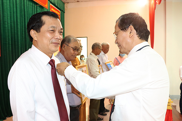 Ông Lương Trí Tiên, Trưởng Ban Nội chính Tỉnh ủy trao Huy hiệu 30 năm tuổi Đảng cho đảng viên Hồ Văn Lợi (Chi bộ 2, Đảng bộ Văn phòng huyện). Ảnh: TUẤN VŨ