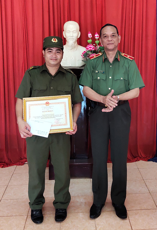 Thiếu tướng Đặng Hoàng Đa trao Bằng khen của Bộ trưởng Bộ Công an cho công an viên Hoàng Xuân Hạnh.