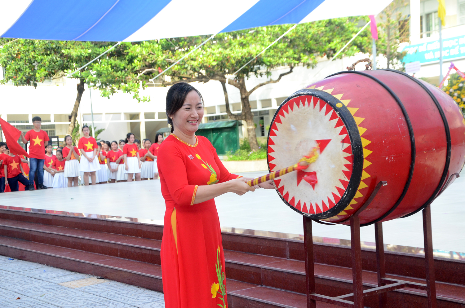 Bà Nguyễn Thị Sông Thương, Hiệu trưởng Trường THCS Nguyễn An Ninh đánh trống khai giảng năm học mới 2020-2021. Ảnh: VÂN ANH