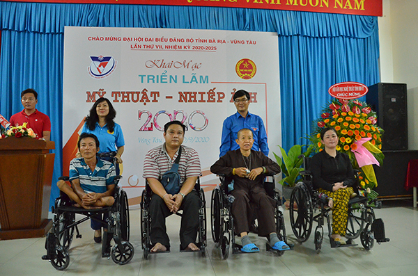 Ban tổ chức triển lãm trao tặng xe lăn cho các trường hợp bị tàn tật có hoàn cảnh khó khăn.