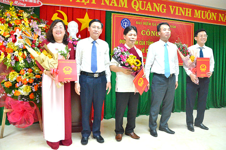 Ông Nguyễn Thế Mạnh, Tổng Giám đốc BHXH Việt Nam và ông Lê Ngọc Khánh, Phó Chủ tịch UBND tỉnh trao quyết định và tặng hoa chúc mừng đến ông Trần Duy Hưng, ông Phạm Ngọc Sơn và bà Nguyễn Hồng Hạnh.  