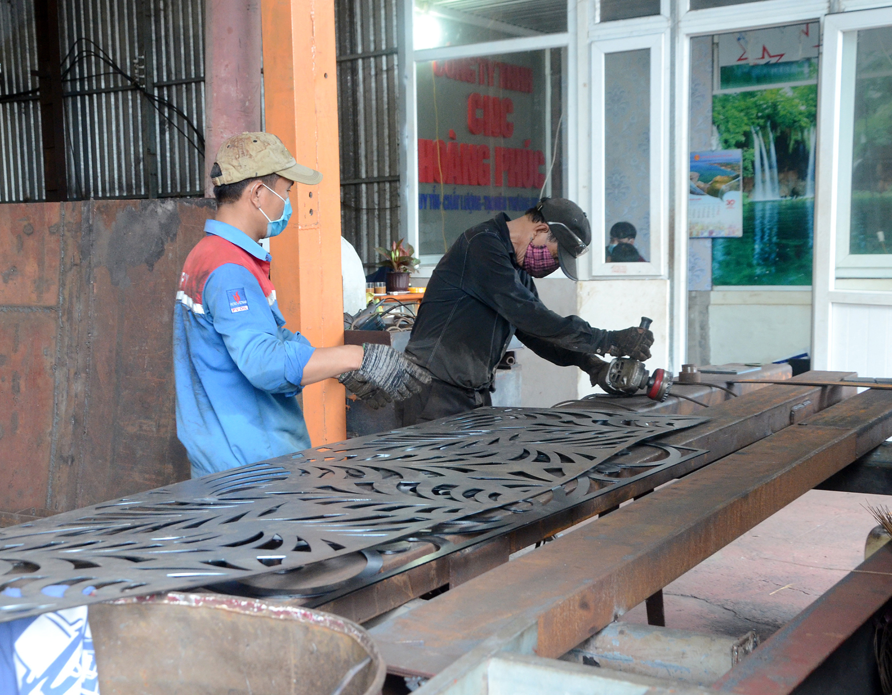 Công nhân Công ty TNHH SX - TM Cơ khí CNC Hoàng Phúc vệ sinh sản phẩm sau khi cắt xong tại xưởng.