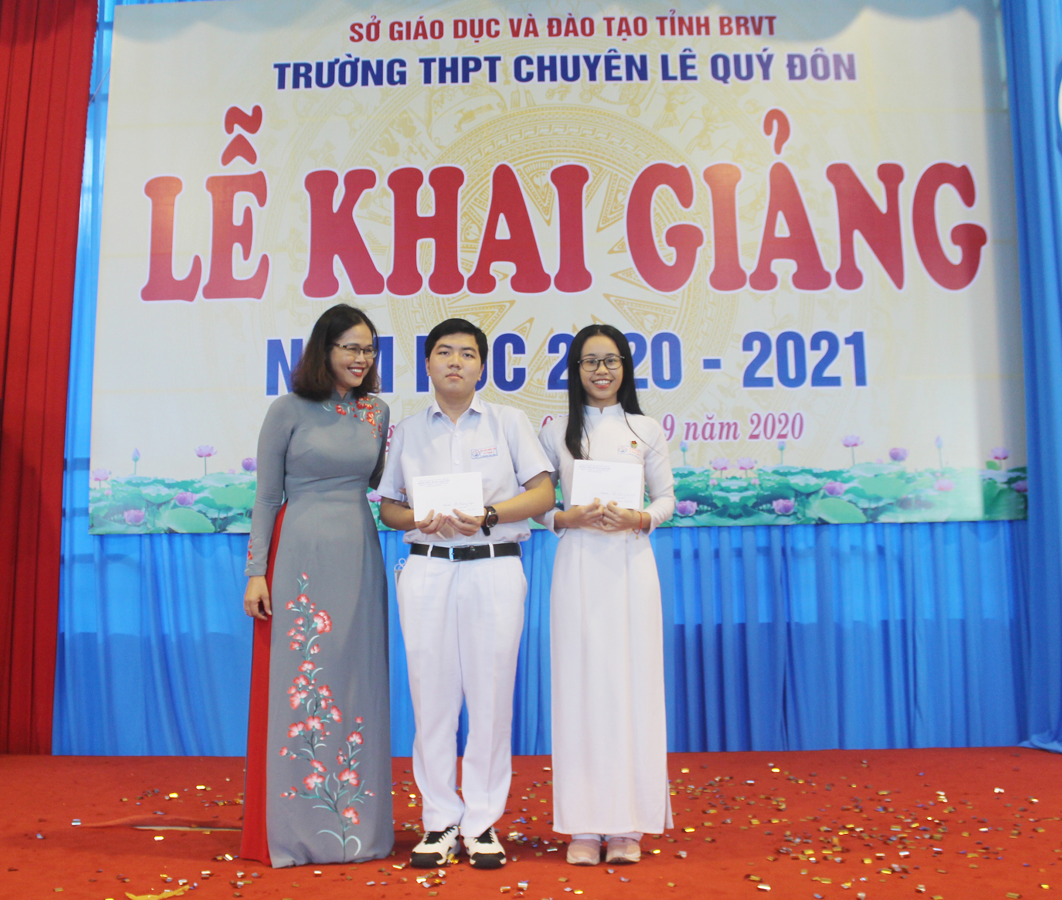 Cô Lữ Thị Trà Giang, Hiệu trưởng Trường THPT chuyên Lê Quý Đôn trao phần thưởng cho hai thủ khoa kỳ thi tốt nghiệp THPT năm 2020. Ảnh: HOÀNG DƯƠNG