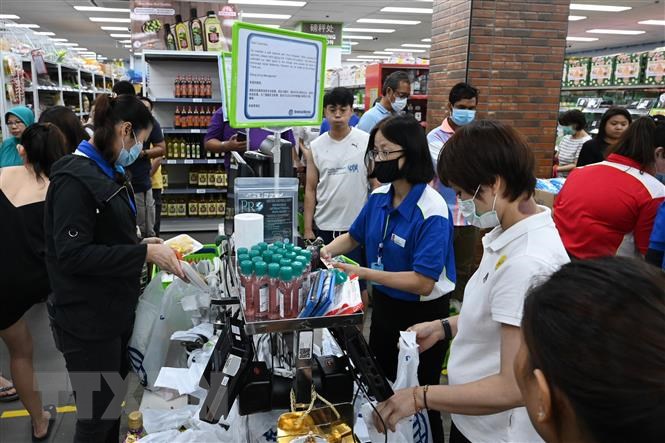 Người dân đeo khẩu trang phòng COVID-19 khi mua hàng tại siêu thị ở Singapore.