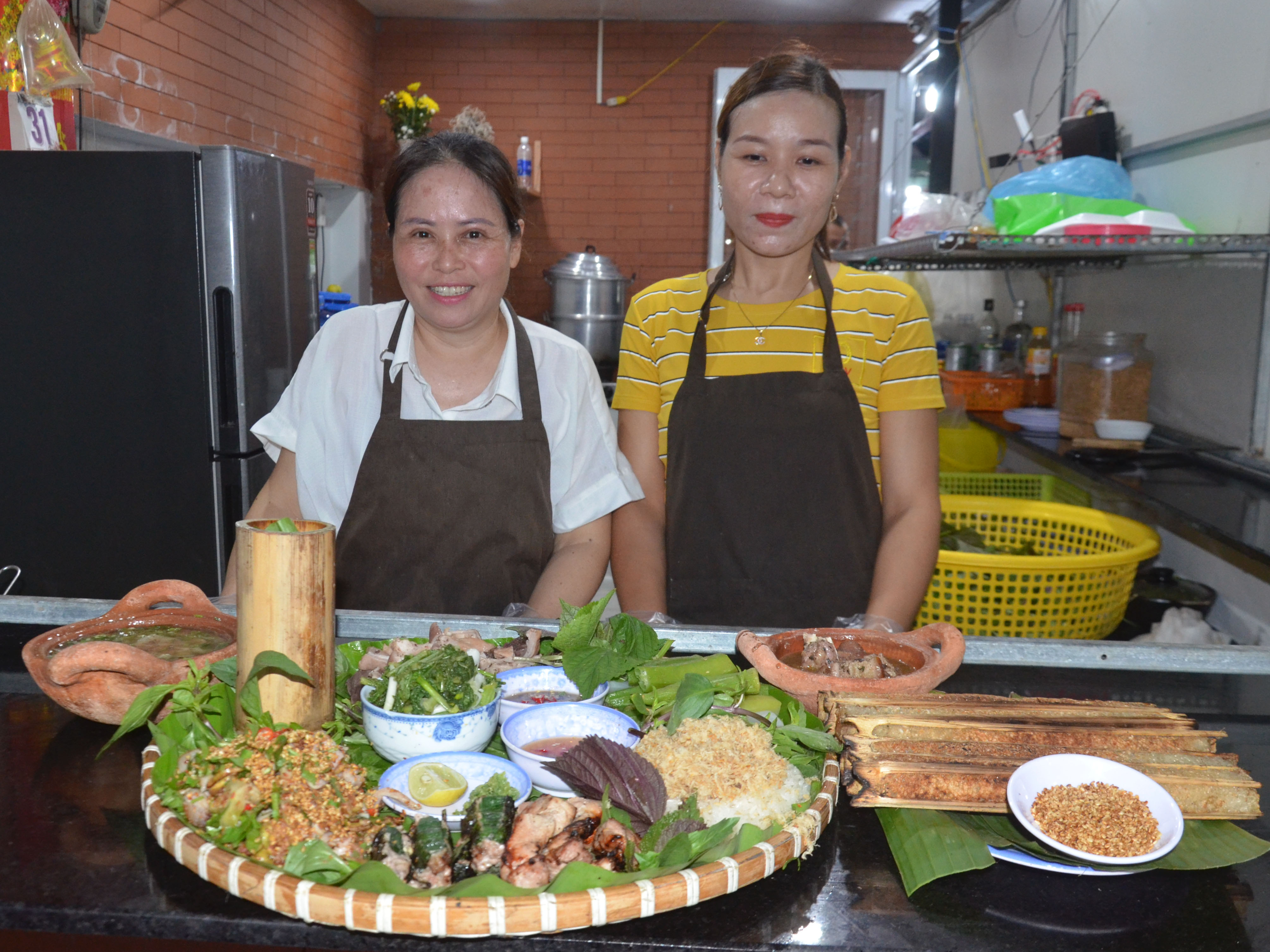 Chị Vũ Thị Huệ (trái) trực tiếp đứng bếp với mong muốn mang đến những món ăn ngon nhất và an toàn cho thực khách. 