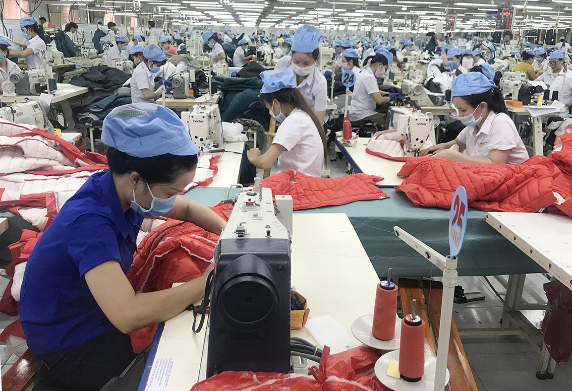 Dịch COVID-19 đã ảnh hưởng tới hoạt động XNK của các DN nên số thu NSNN giảm. Trong ảnh: Công nhân Công ty Quốc tế Việt An sản xuất các sản phẩm may mặc xuất khẩu.