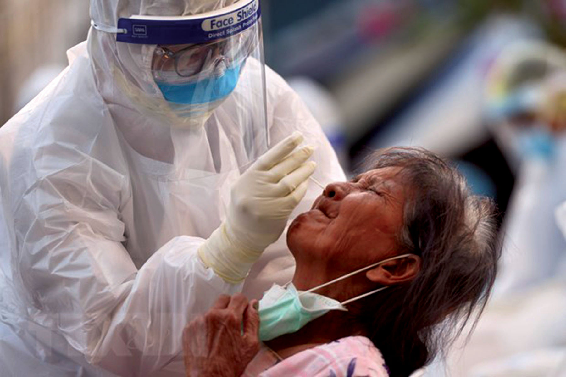 Nhân viên y tế lấy mẫu dịch xét nghiệm COVID-19 cho người dân tại tỉnh Samut Sakhon, Thái Lan. 