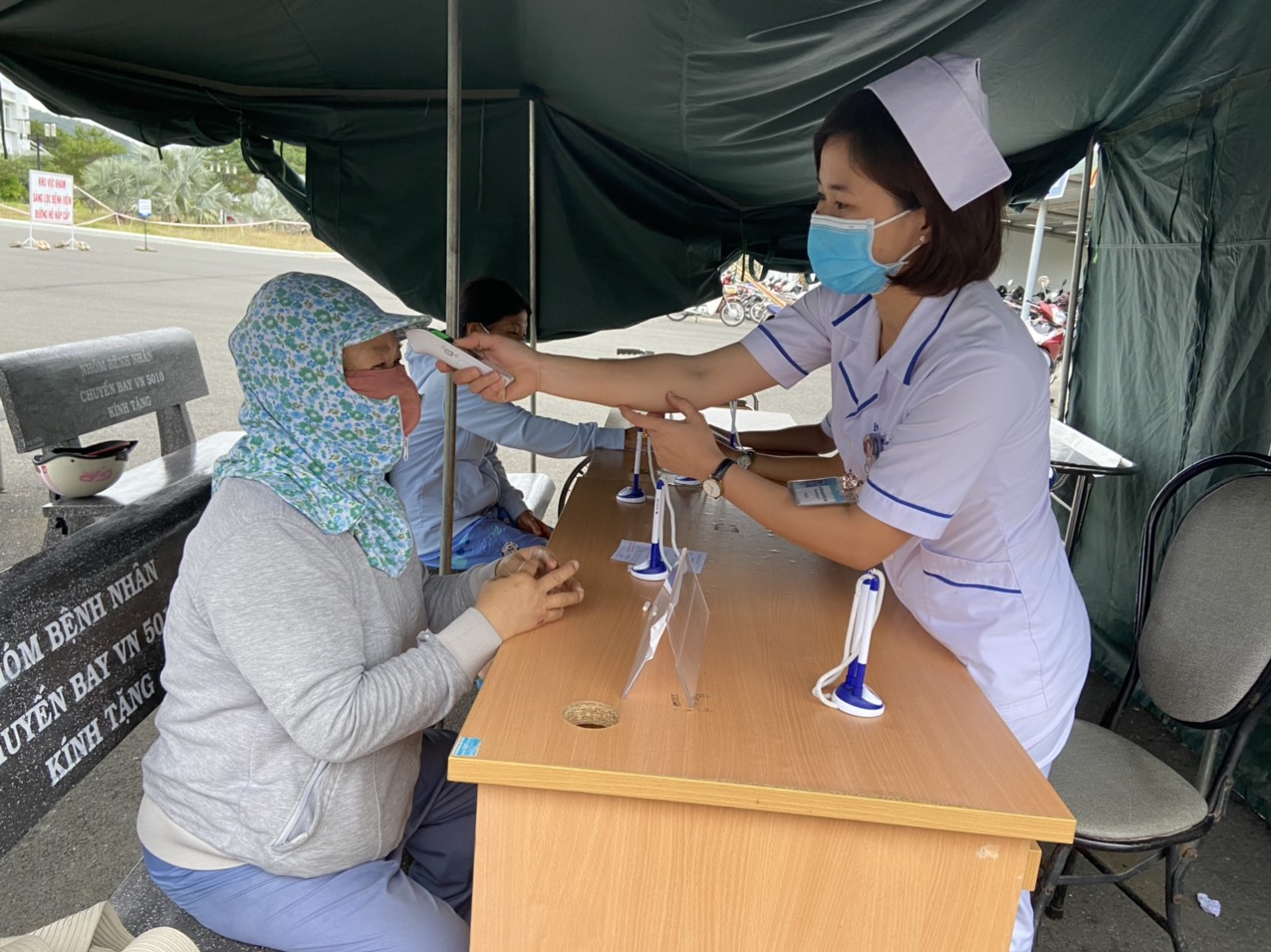 Nhân viên Trung tâm Y tế huyện Long Điền kiểm tra thân nhiệt cho người dân đến khám bệnh.