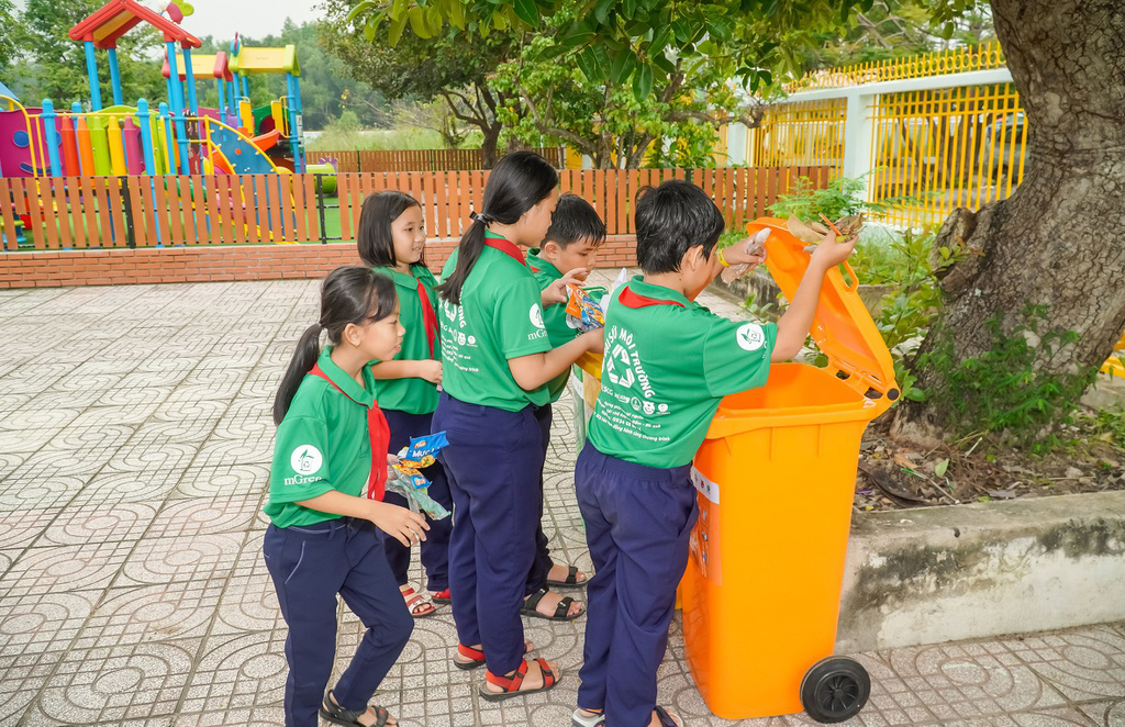 Học sinh Trường TH Long Sơn 2 bỏ rác sau khi phân loại vào thùng.