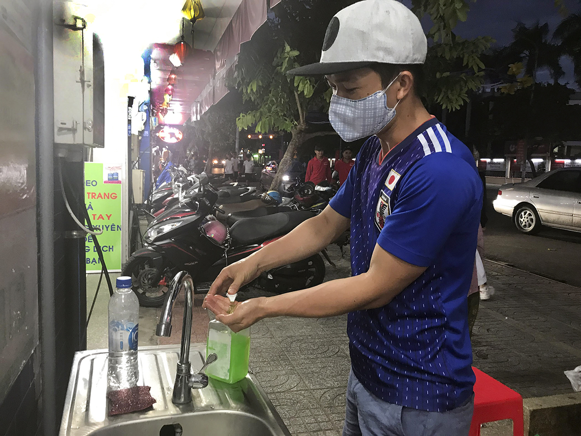 Người dân rửa tay sát khuẩn trước khi vào mua sắm tại cửa hàng tự chọn Phước Trung (TP. Bà Rịa).
