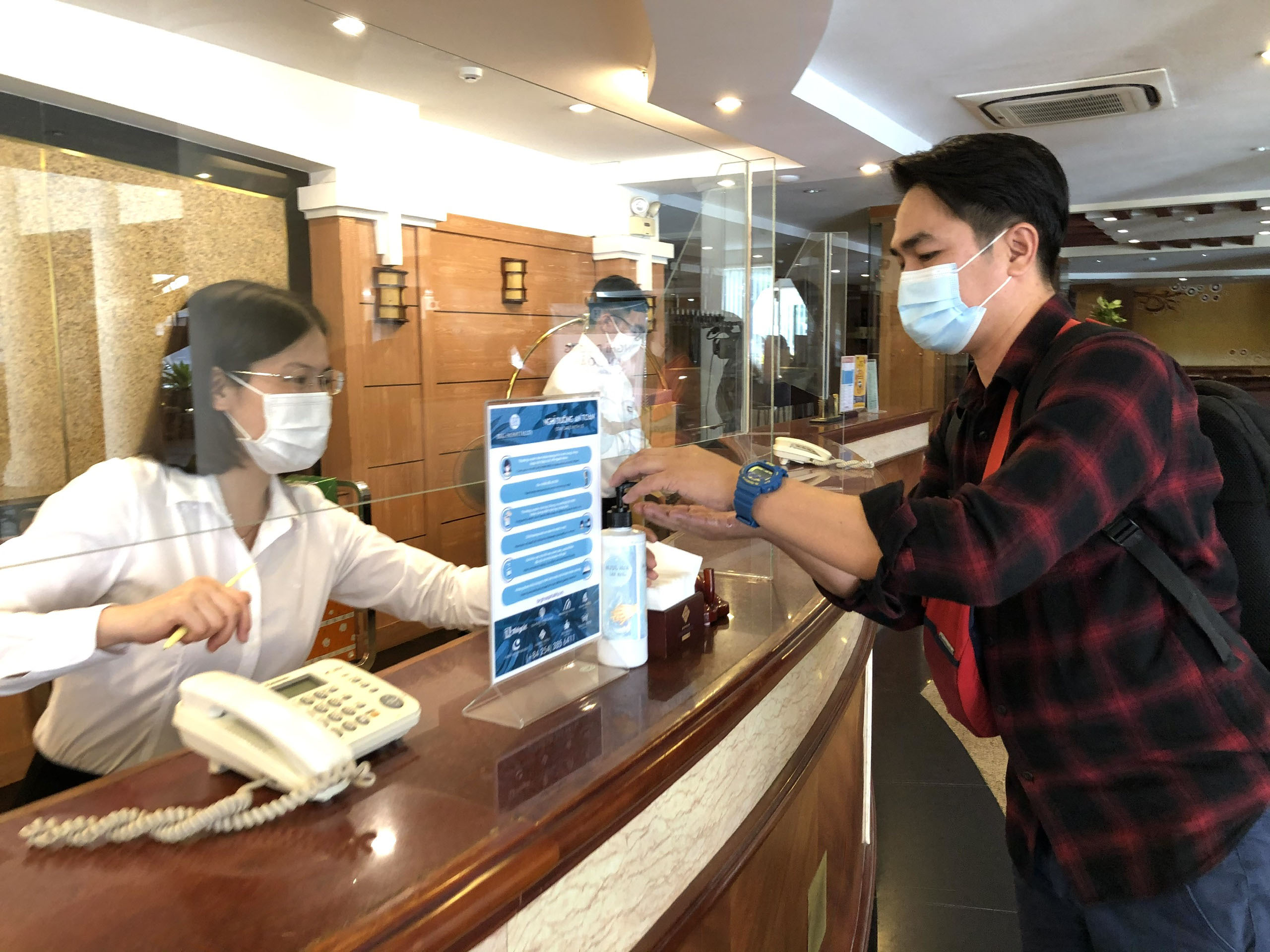 Khách đến khách sạn Palace được yêu cầu rửa tay sát khuẩn trước khi làm thủ tục nhận phòng.
