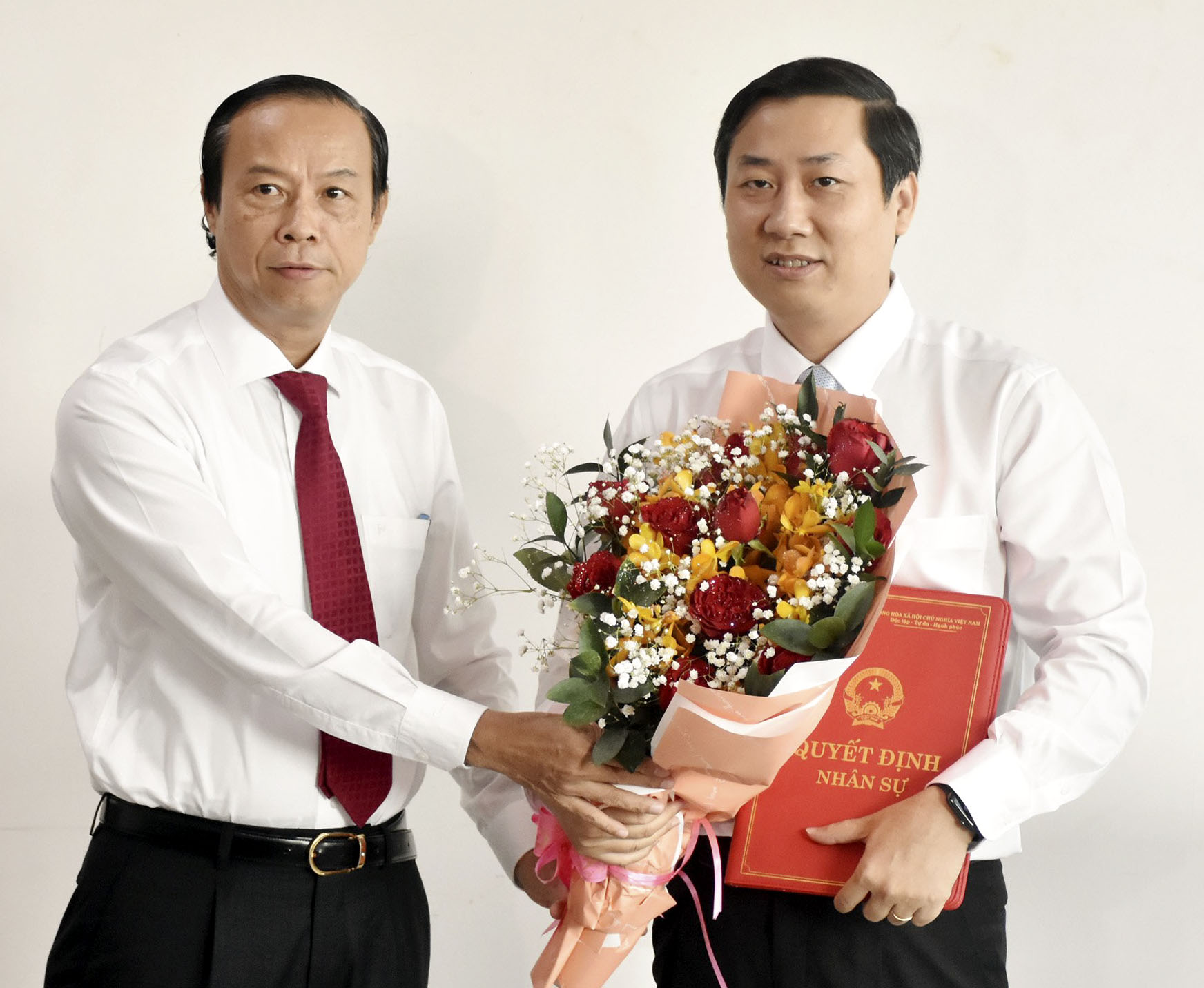 Ông Nguyễn Văn Thọ (bìa trái), Phó Bí thư Tỉnh ủy, Chủ tịch UBND tỉnh trao Quyết định và tặng hoa chúc mừng ông Nguyễn Công Danh.