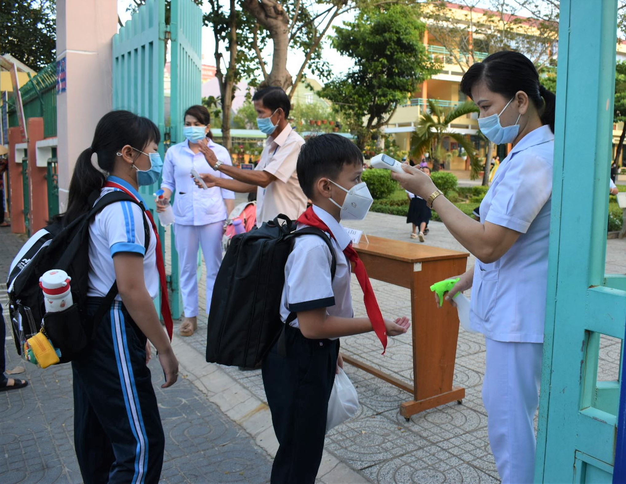 Nhân viên y tế kiểm tra thân nhiệt và sát khuẩn cho HS trước khi vào lớp tại trường TH Lê Thành Duy, TP. Bà Rịa. 