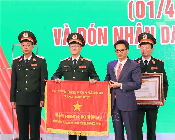 Thay mặt lãnh đạo Đảng, Nhà nước, Phó Thủ tướng Vũ Đức Đam trao Danh hiệu Anh hùng Lao động thời kỳ đổi mới cho Bệnh viện Trung ương Quân đội 108. Ảnh: TTXVN