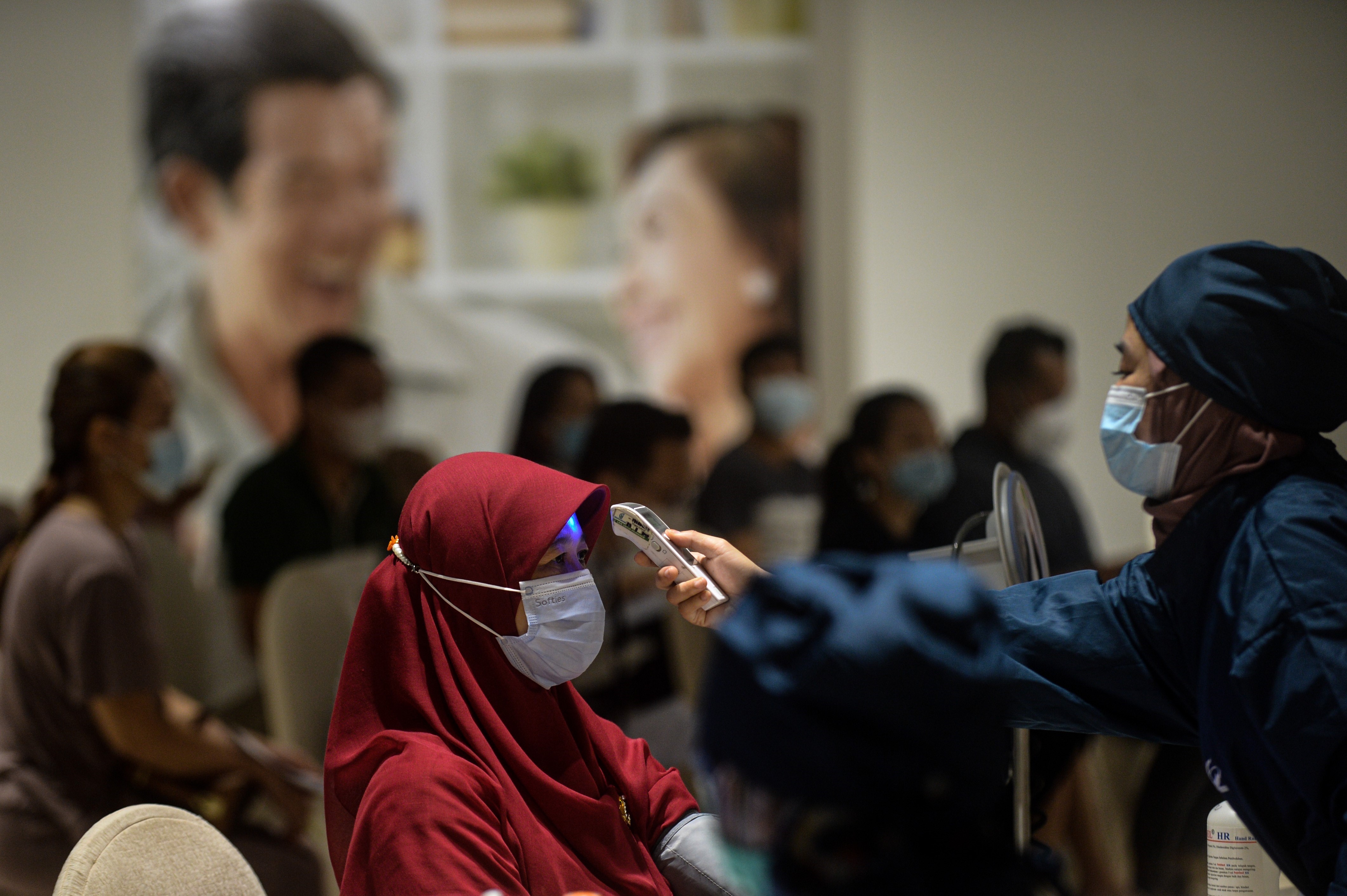Nhân viên y tế kiểm tra thân nhiệt phòng lây nhiễm COVID-19 tại Jakarta (Indonesia).