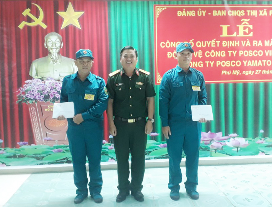 Thượng tá Trần Văn Cư, Chỉ huy trưởng Ban CHQS TX.Phú Mỹ (đứng giữa) trao quyết định thành lập Trung đội tự vệ cho đại diện 2 DN FDI.
