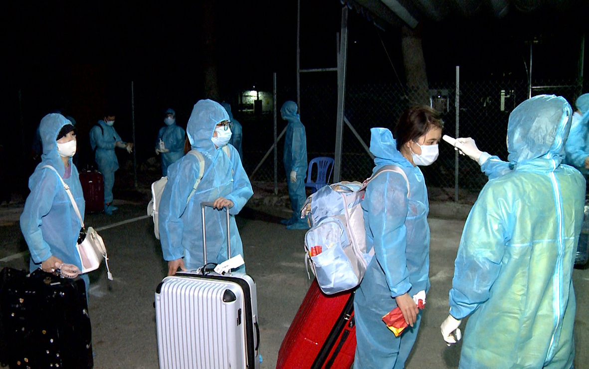Nhân viên y tế kiểm tra thân nhiệt các công dân Việt Nam trở về từ Nhật Bản.