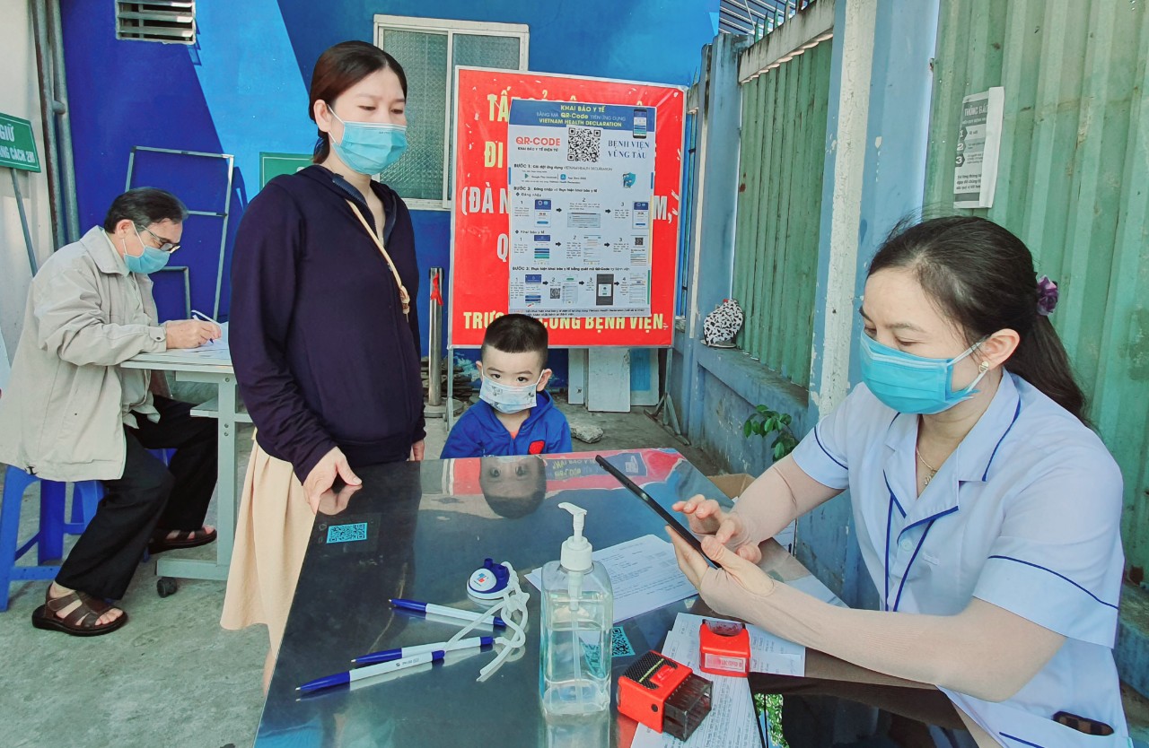 Nhân viên Bệnh viện Vũng Tàu hỗ trợ người dân khai báo y tế trước khi vào bệnh viện. 