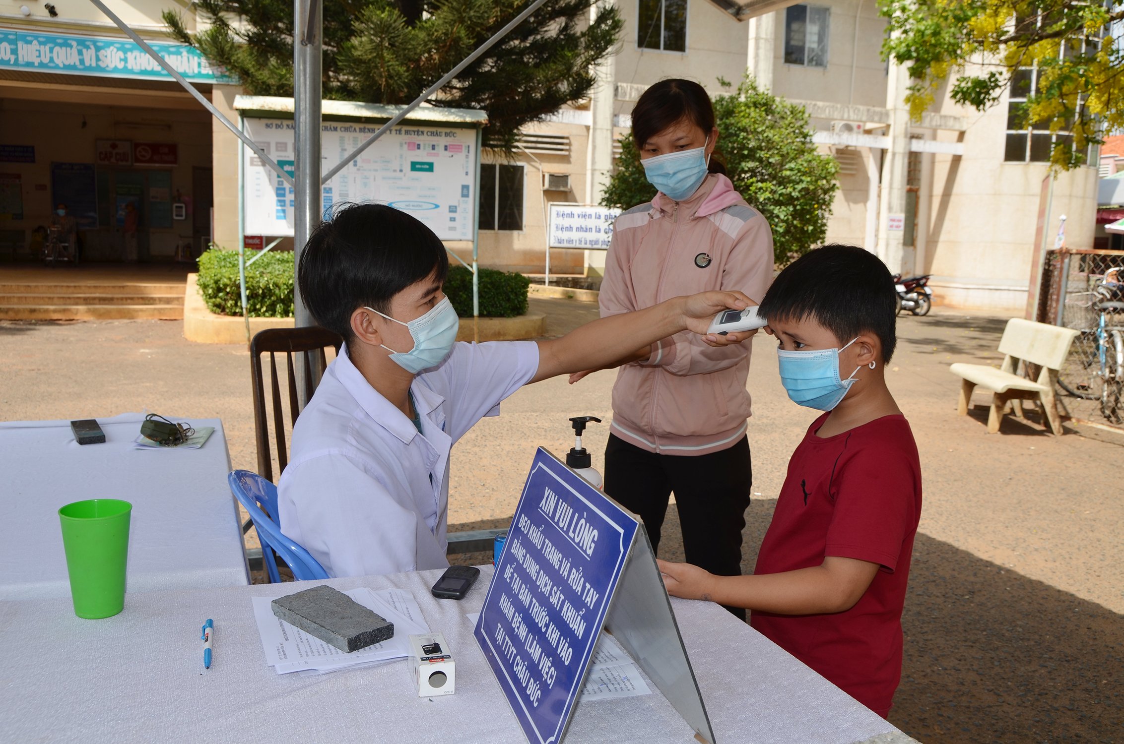 Nhân viên y tế tại Trung tâm Y tế huyện Châu Đức kiểm tra thân nhiệt những người dân ra, vào trung tâm. Ảnh: DIỄM QUỲNH