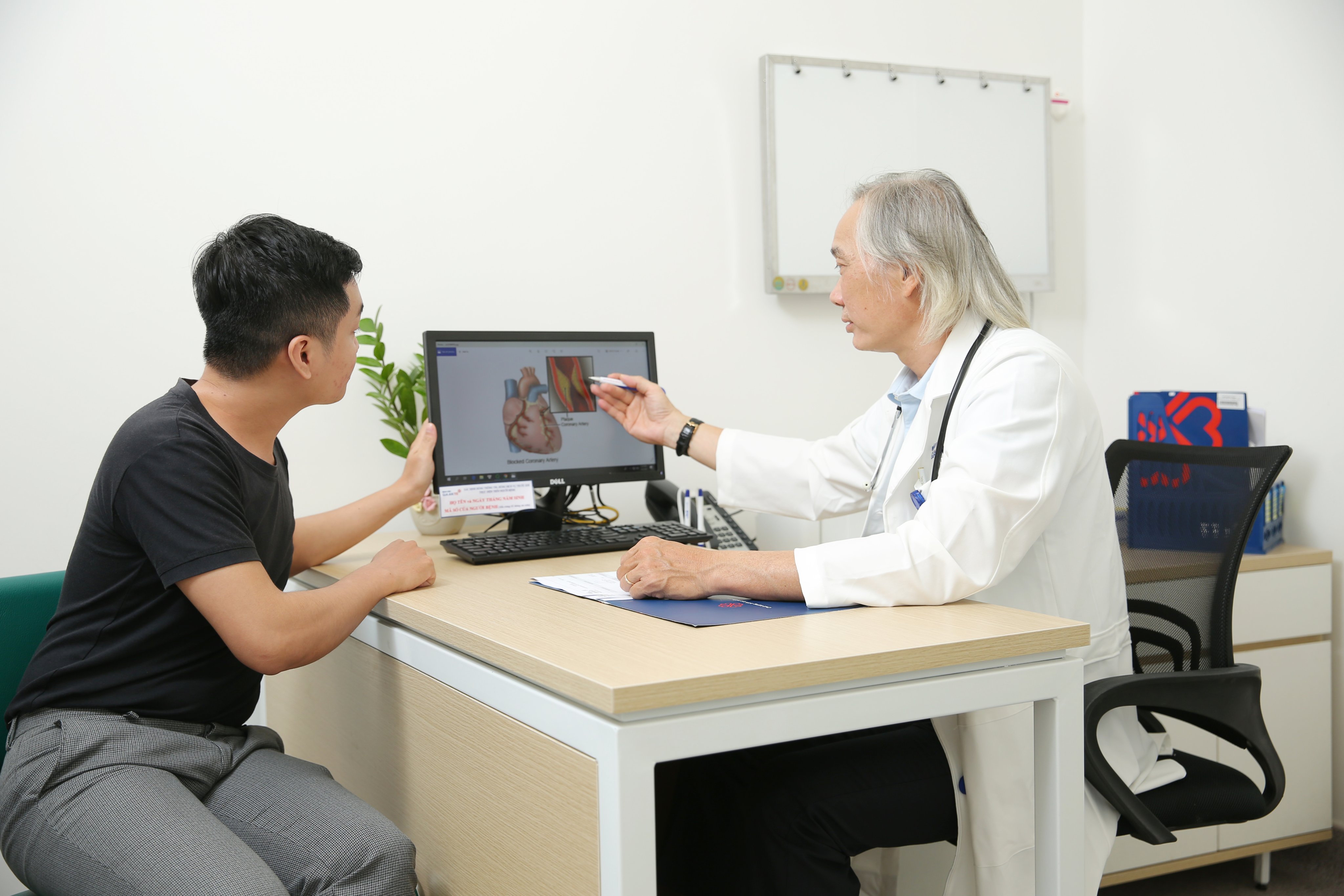 Bác sĩ đang tư vấn cho một người bệnh trẻ tuổi về vấn đề tim mạch.